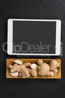Ginger and garlic in tray with digital tablet