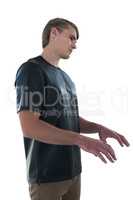 Side view of young man gesturing against white background