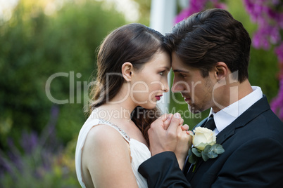 Close up of newlywed couple romancing in park