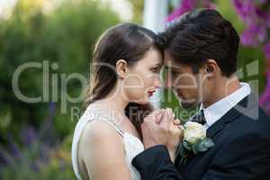 Close up of newlywed couple romancing in park