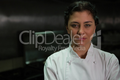 Female chef standing in commercial kitchen Female chef standing in commercial kitchen