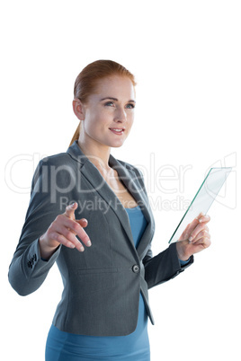 Smiling businesswoman touching on imaginary screen while using glass interface Smiling businesswoman touching on imaginary screen while using glass interface