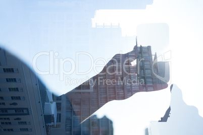 Businessman holding smart phone reflecting on window