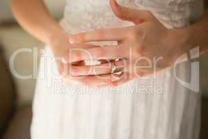 Midsection of bride wearing wedding ring at home