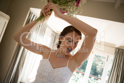 Tilt image of angry bride throwing bouquet at home