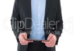 Mid section of businessman holding tablet computer