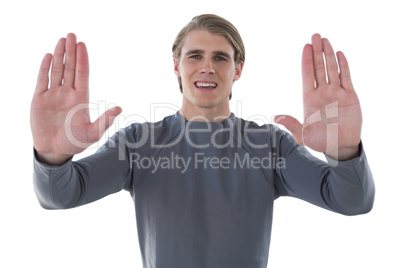 Portrait of smiling young businessman gesturing against white background