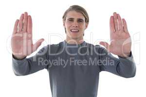Portrait of smiling young businessman gesturing against white background