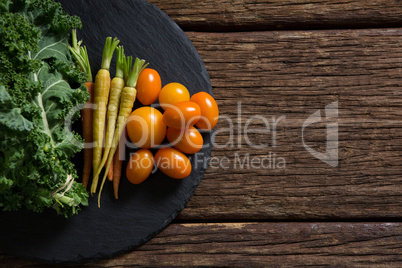 Mustard greens, carrots and tomatoes on tray