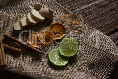 Sliced ginger, dried orange and lemon with cinnamon stick on textile