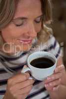 Happy woman smelling coffee