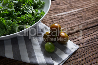 Mustard greens and gooseberry on wooden table