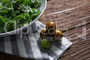 Mustard greens and gooseberry on wooden table