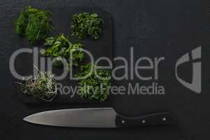 Various herbs on chopping board with knife