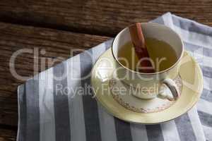 Cup of tea with cinnamon stick on napkin