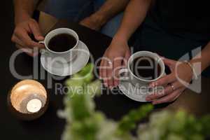 Mid section of couple having coffee