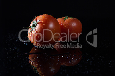 Fresh tomatoes on black background