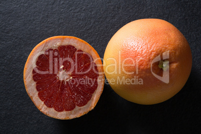 Grapefruit with half grapefruit on black background