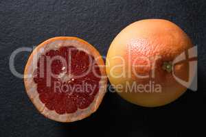 Grapefruit with half grapefruit on black background