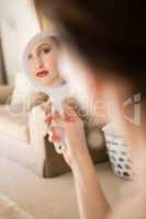 Beautiful bride looking into hand mirror