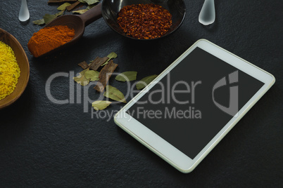 Spices powder with digital tablet on table