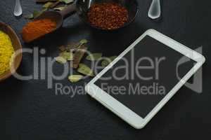 Spices powder with digital tablet on table