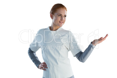 Smiling businesswoman gesturing while standing with hand on hip