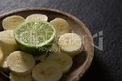 Sliced banana with halved lemon on plate