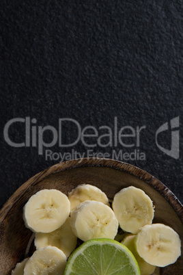 Sliced banana with halved lemon on plate