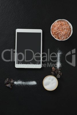 Various salt in bowl with digital tablet