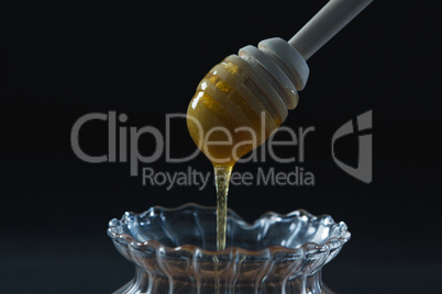 Honey pouring into a jar