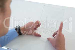High angle view of businessman using glass interface at table