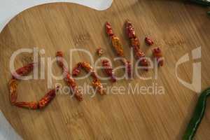 Dried red chili pepper arranged in chili text with green chili