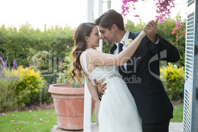 Romantic newlywed couple dancing in park