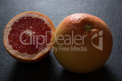 Grapefruit with half grapefruit on black background