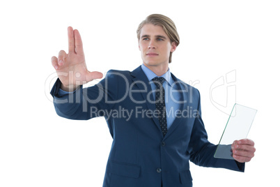 Confident businessman holding glass interface while touching imaginary screen