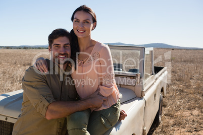 Portrait of woman with man sitting on off road vehicle
