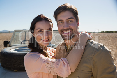 Portrait of smiling couple by off road vehicle