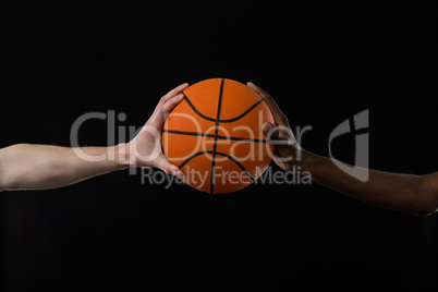 Competitors holding basketball against black background