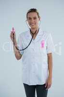 Female doctor with stethoscope showing Breast Cancer Awareness ribbons