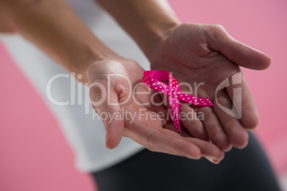Close-up of woman holding spotted pink ribbon