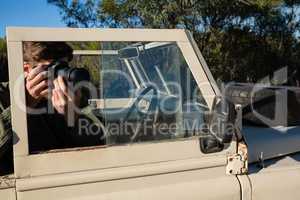 Man photographing while sitting in off road vehicle