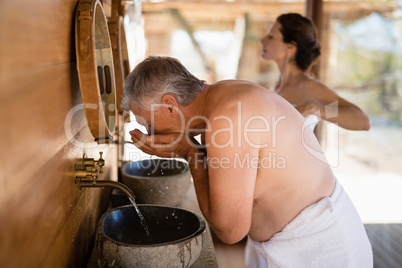 Man washing face from water in cottage