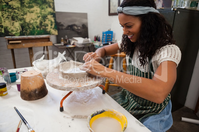 Happy woman molding clay