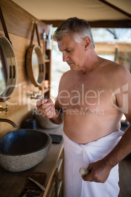Man looking at razor in cottage