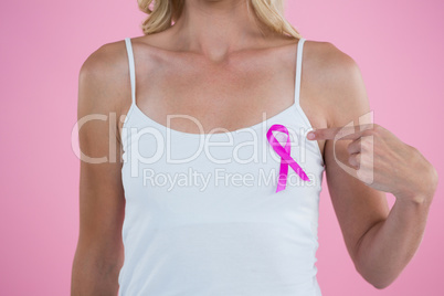 Mid section of woman pointing on Breast Cancer Awareness ribbon