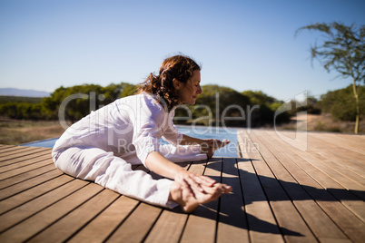 Woman practicing yoga on wooden plank