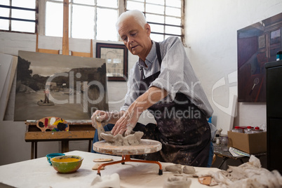 Portrait of senior man molding clay