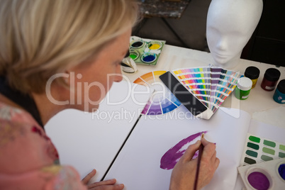 Woman painting in drawing book