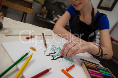 Attentive woman sketching in drawing book